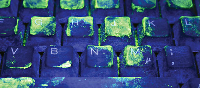 Common keyboard viewed under special UV light showing the presence of bacteria.